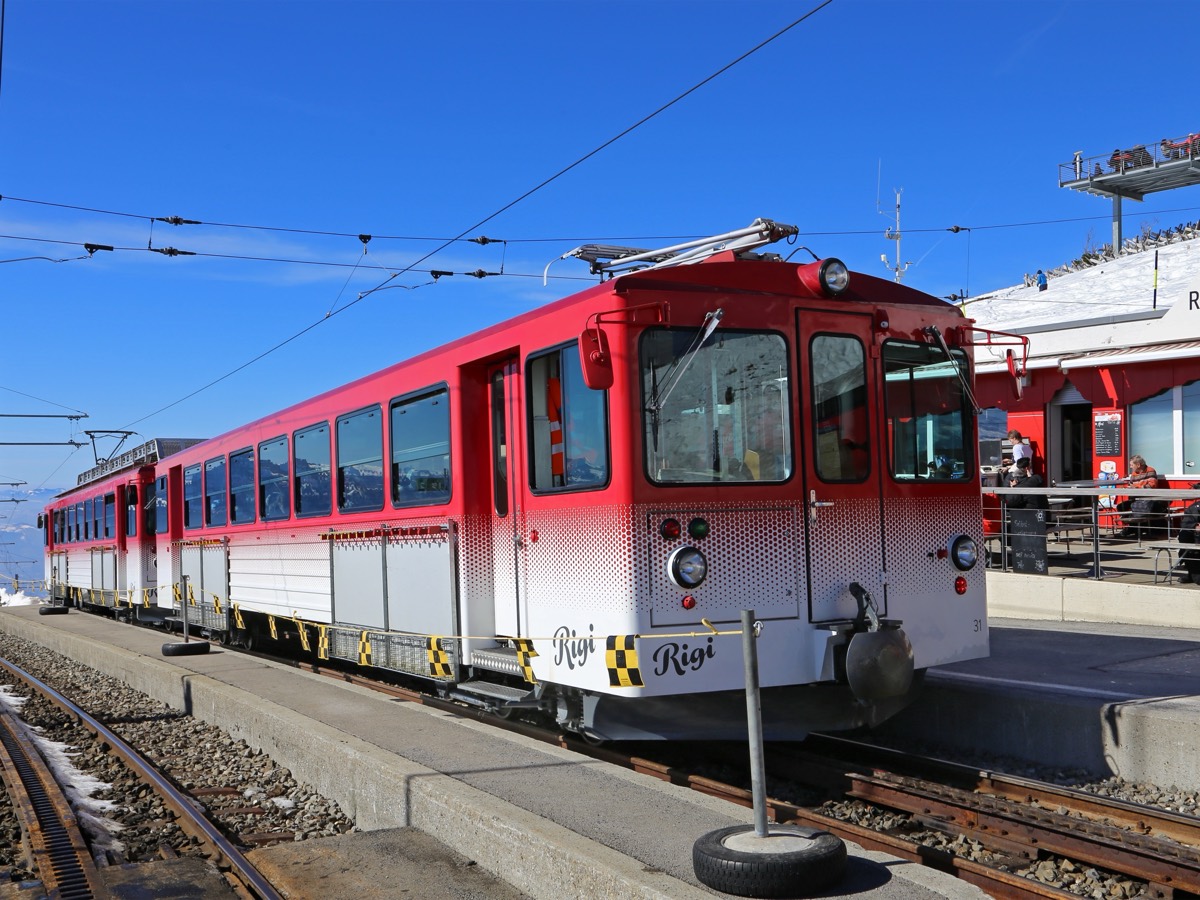 A red Vitznau–Rigi railway train at Rigi Kulm station on Mount Rigi