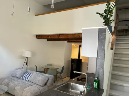 Séjour et escalier en bois menant à la mezzanine